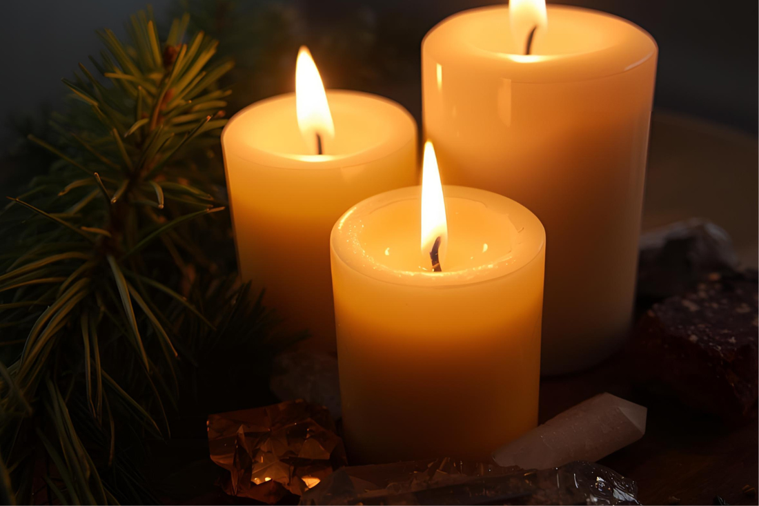 Candlelight glowing beside pine branches and crystals, symbolising Yule magic and the return of the Sun. Warm golden tones and celestial atmosphere from The Triple Moon Blog.