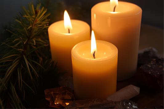 Candlelight glowing beside pine branches and crystals, symbolising Yule magic and the return of the Sun. Warm golden tones and celestial atmosphere from The Triple Moon Blog.